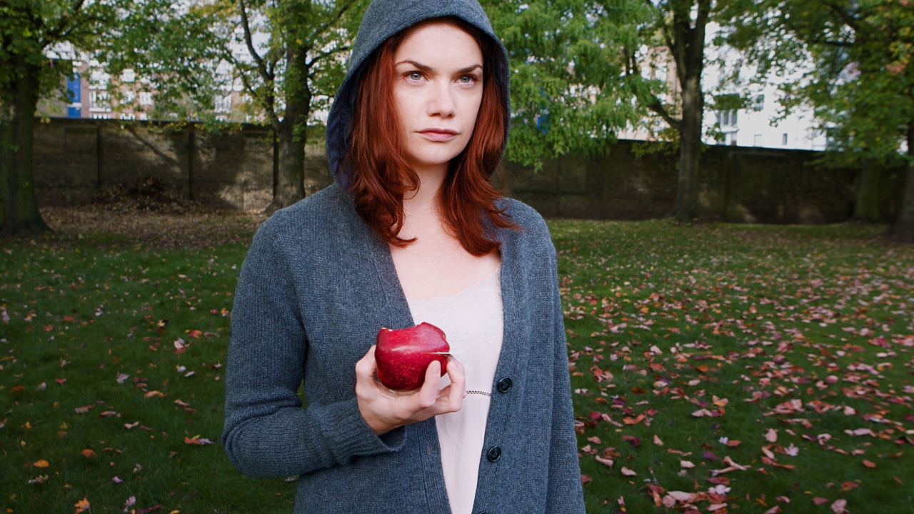 Девушка в капюшоне с яблоком