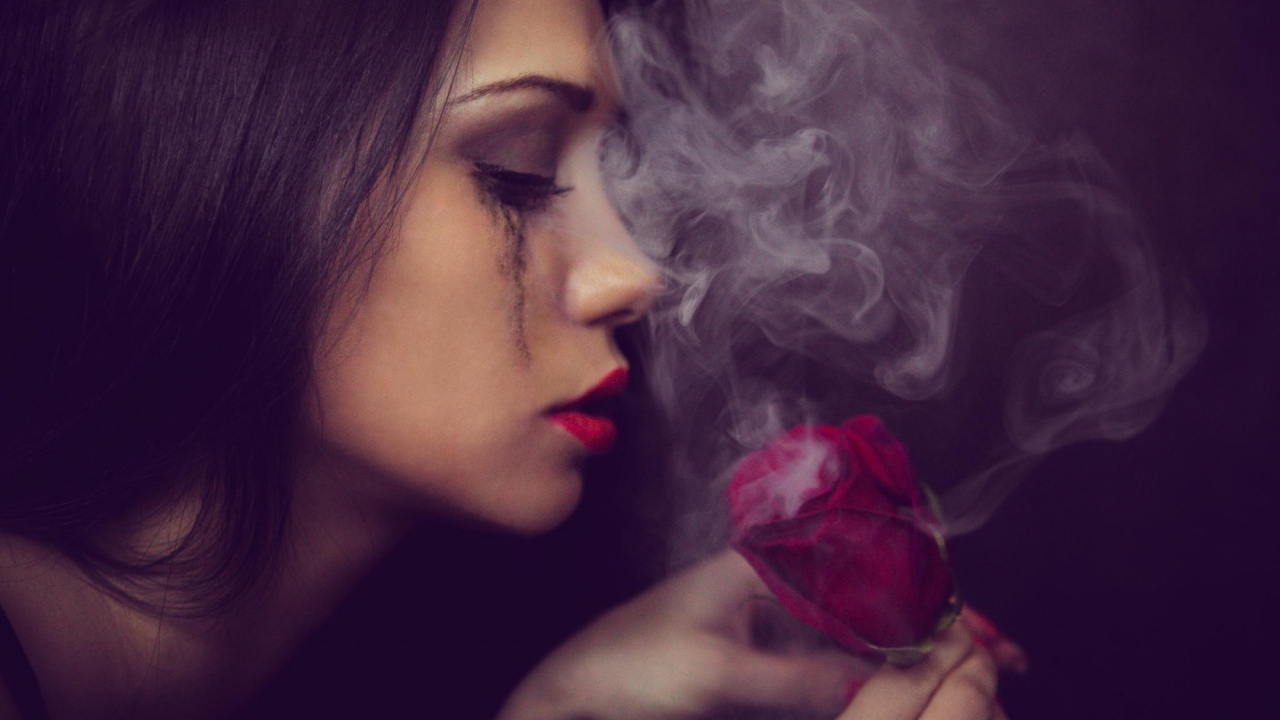 Девушка смотрит на дымящуюся розу