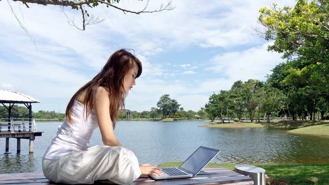 Девушка с ноутбуком у озера