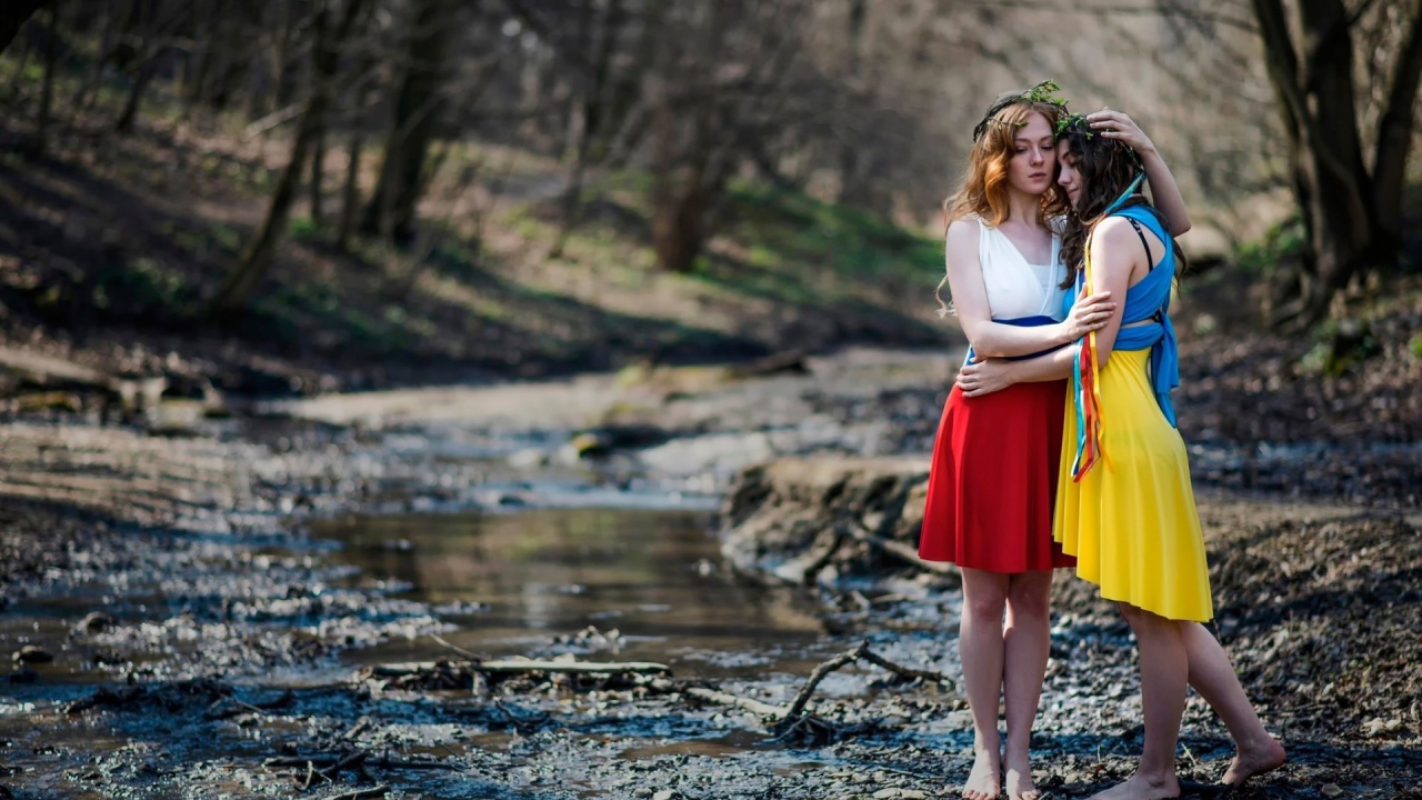 Две девушки в ярких платьях в чаще леса
