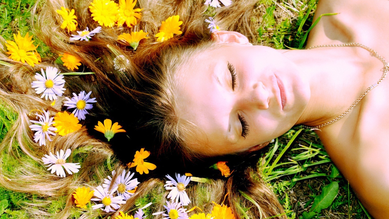 Белые и желтые цветы в волосах у девушки