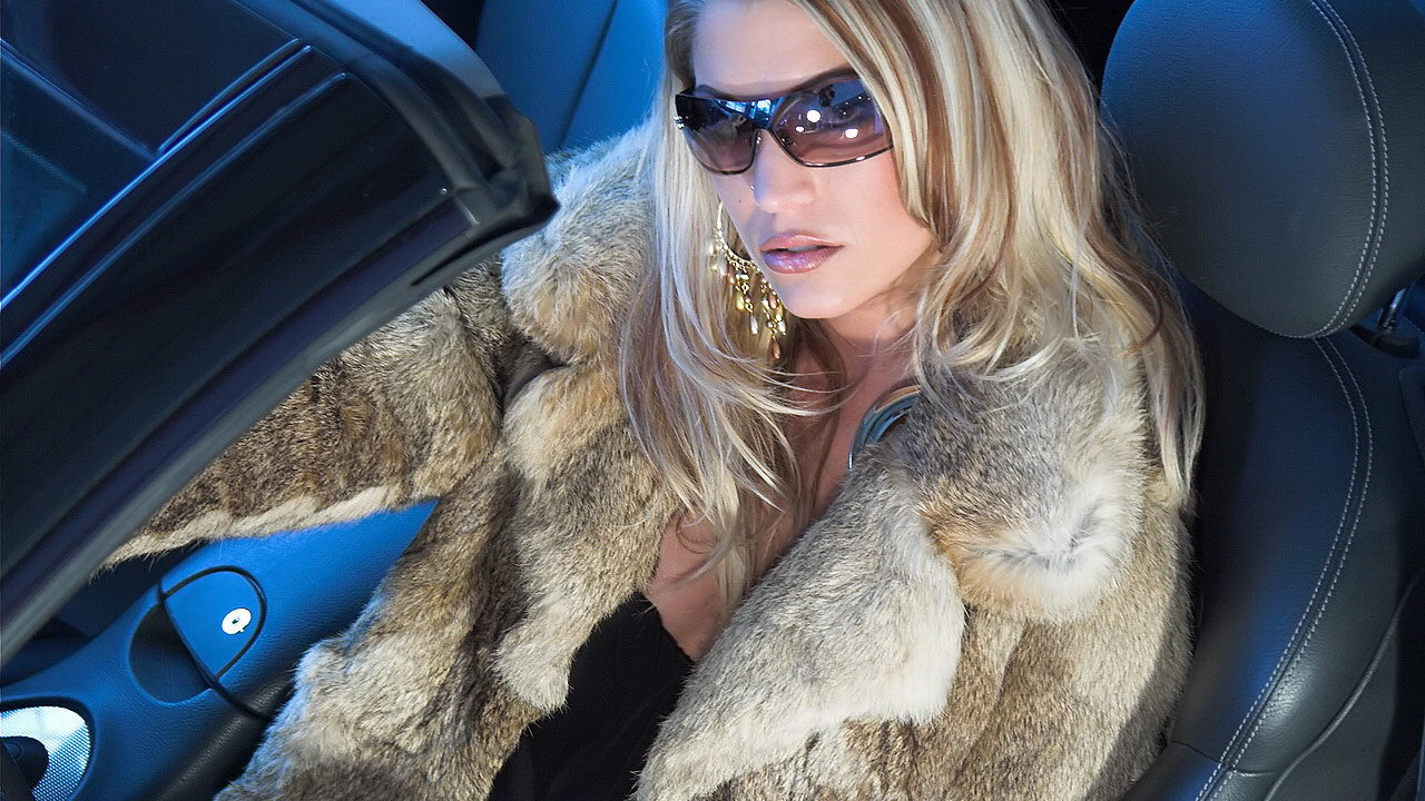 Girl in a fur coat sitting in the car