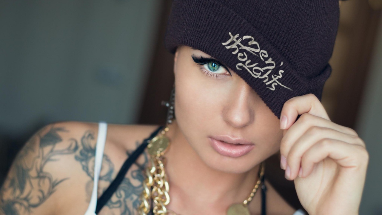 Модель с татуировками и золотой цепью на шее