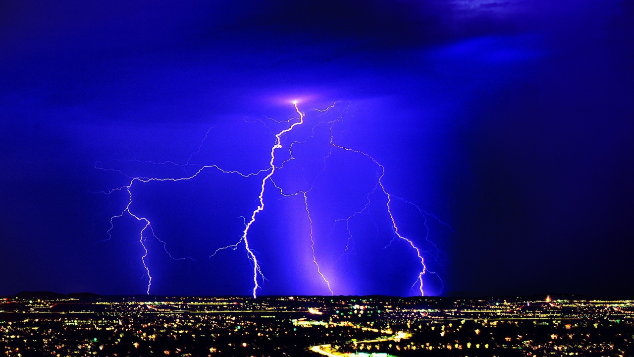 Молния в синем небе над ночным городом
