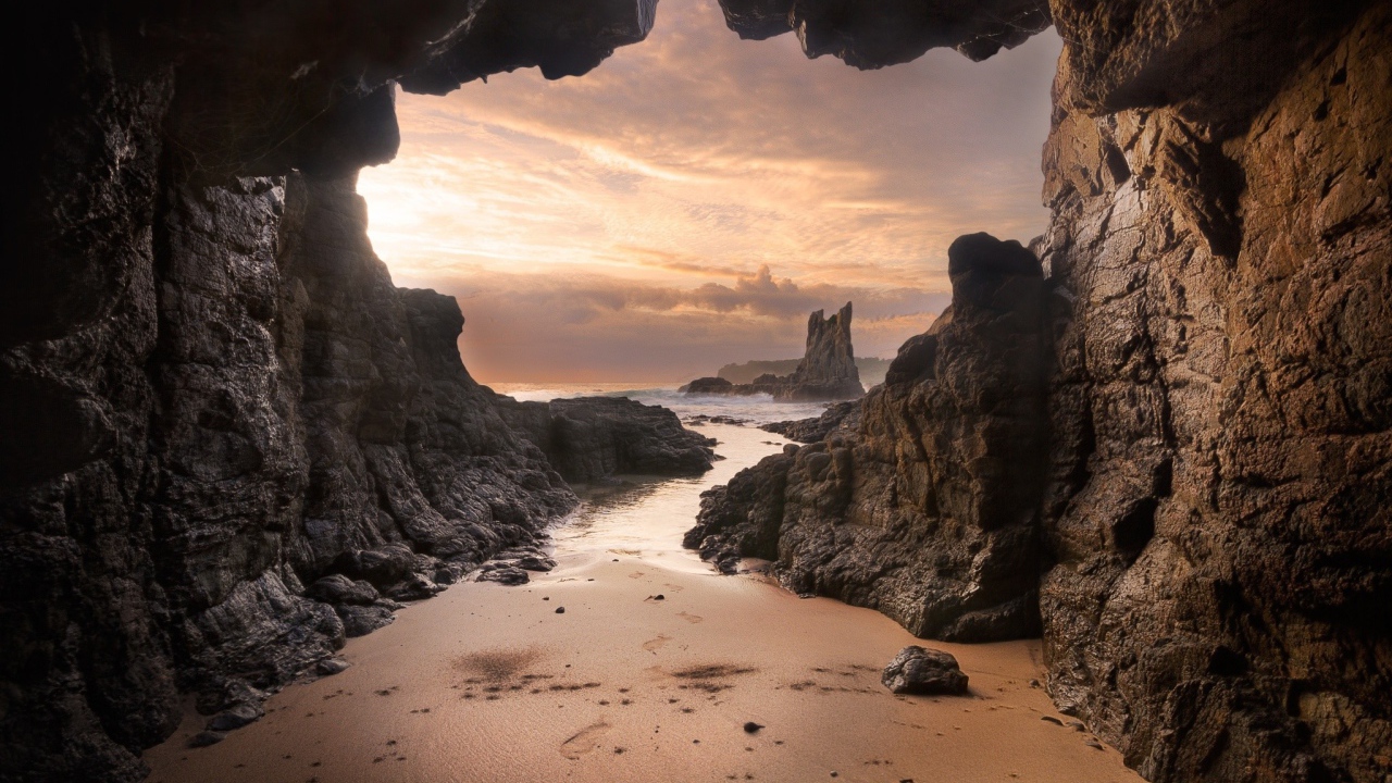 Мокрый песок у входа в пещеру