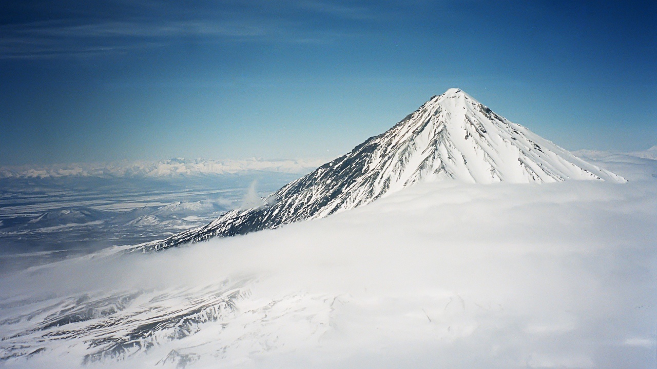 Вершина покрытой снегом горы в облаке