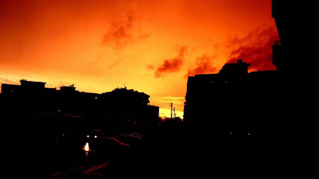 Силуэты зданий на фоне оранжевого неба
