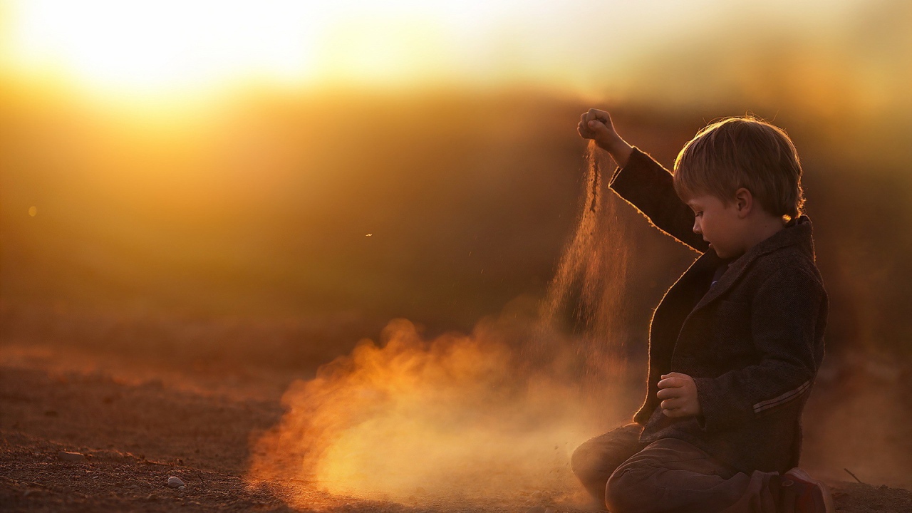 Мальчик играет песком