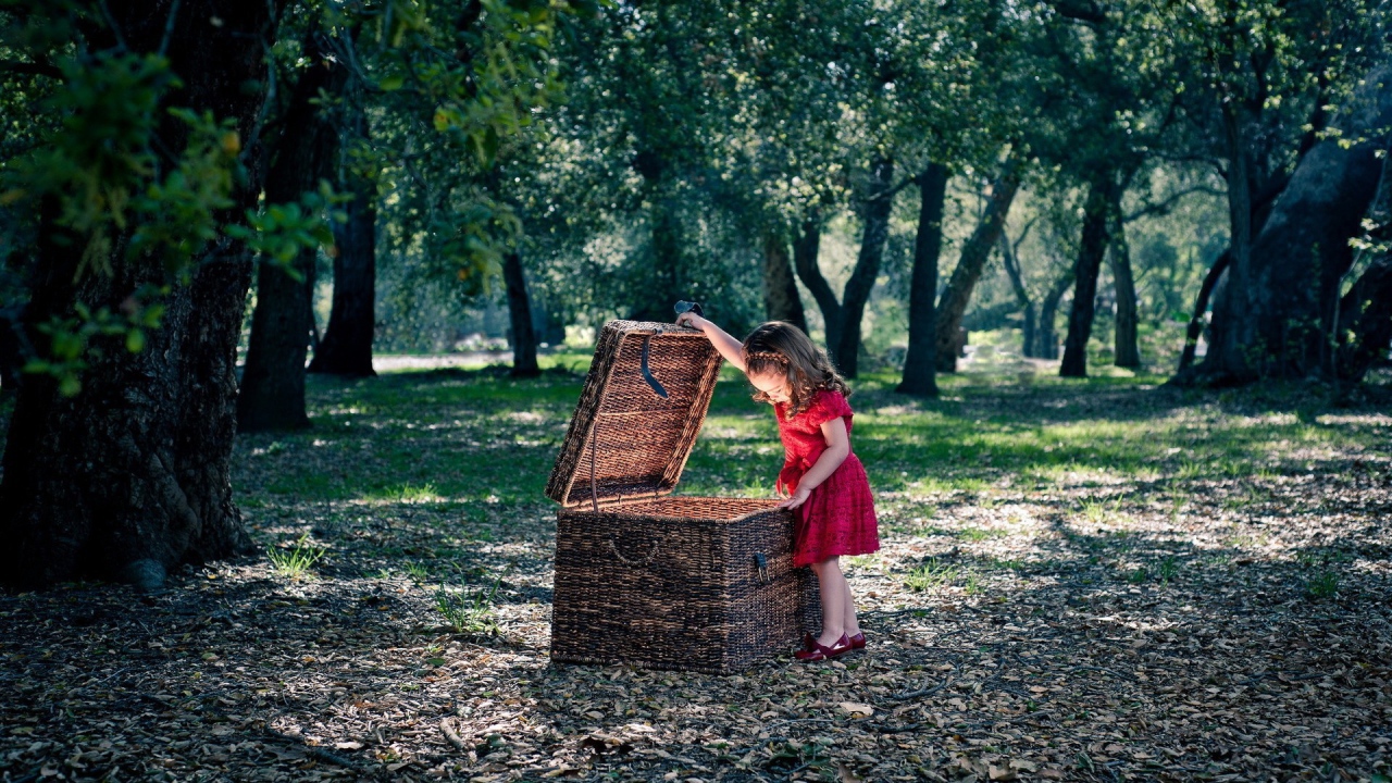 Девочка заглядывает в плетеную корзину