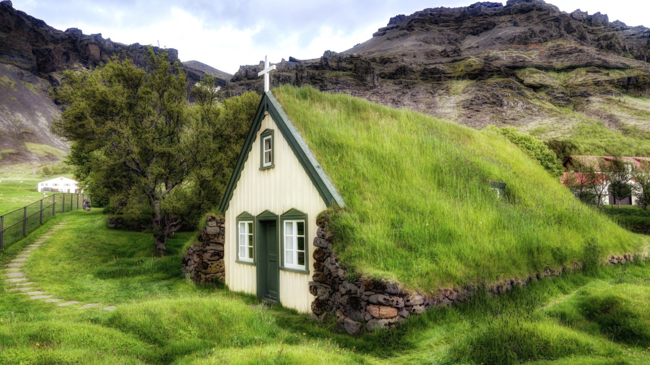 Поросшая травой крыша церкви в горной деревушке