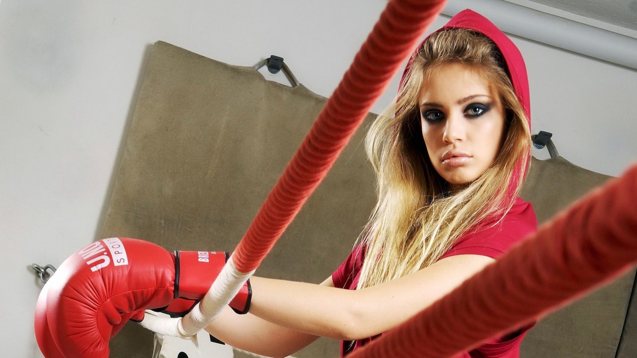 Блондинка в перчатках на боксерском ринге