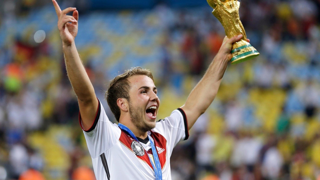 Немецкий футболист Марио Гётце держит в руке кубок