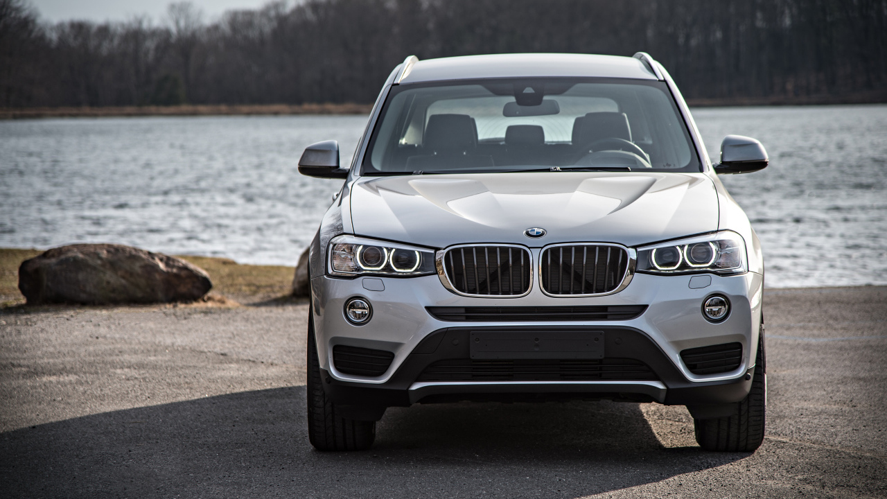 Серебристый автомобиль BMW X3 у водоема 
