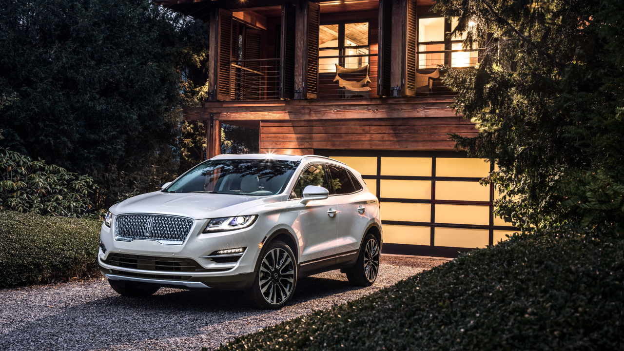 Серебристый автомобиль Lincoln MKC, 2019 у ворот гаража