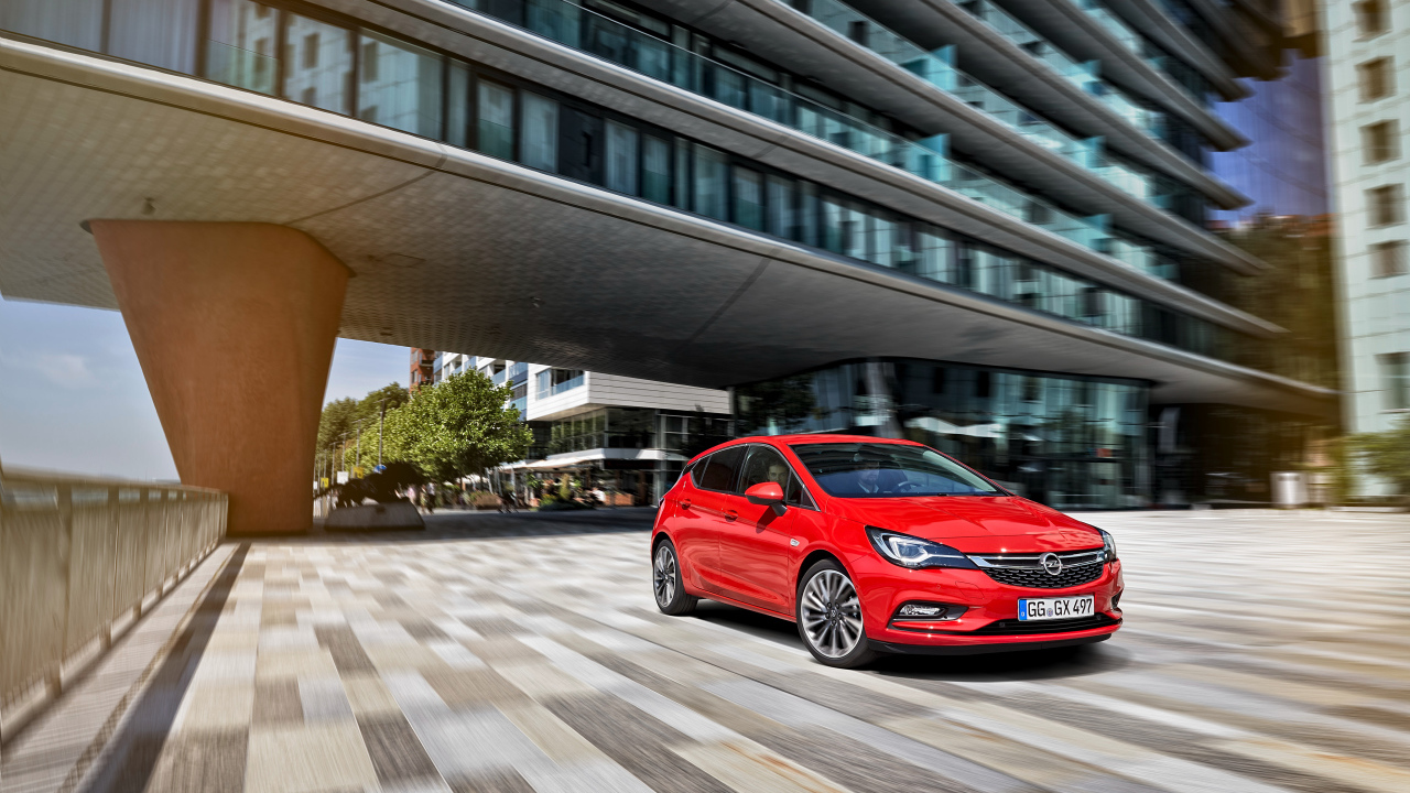 Красный автомобиль Opel Astra в движении