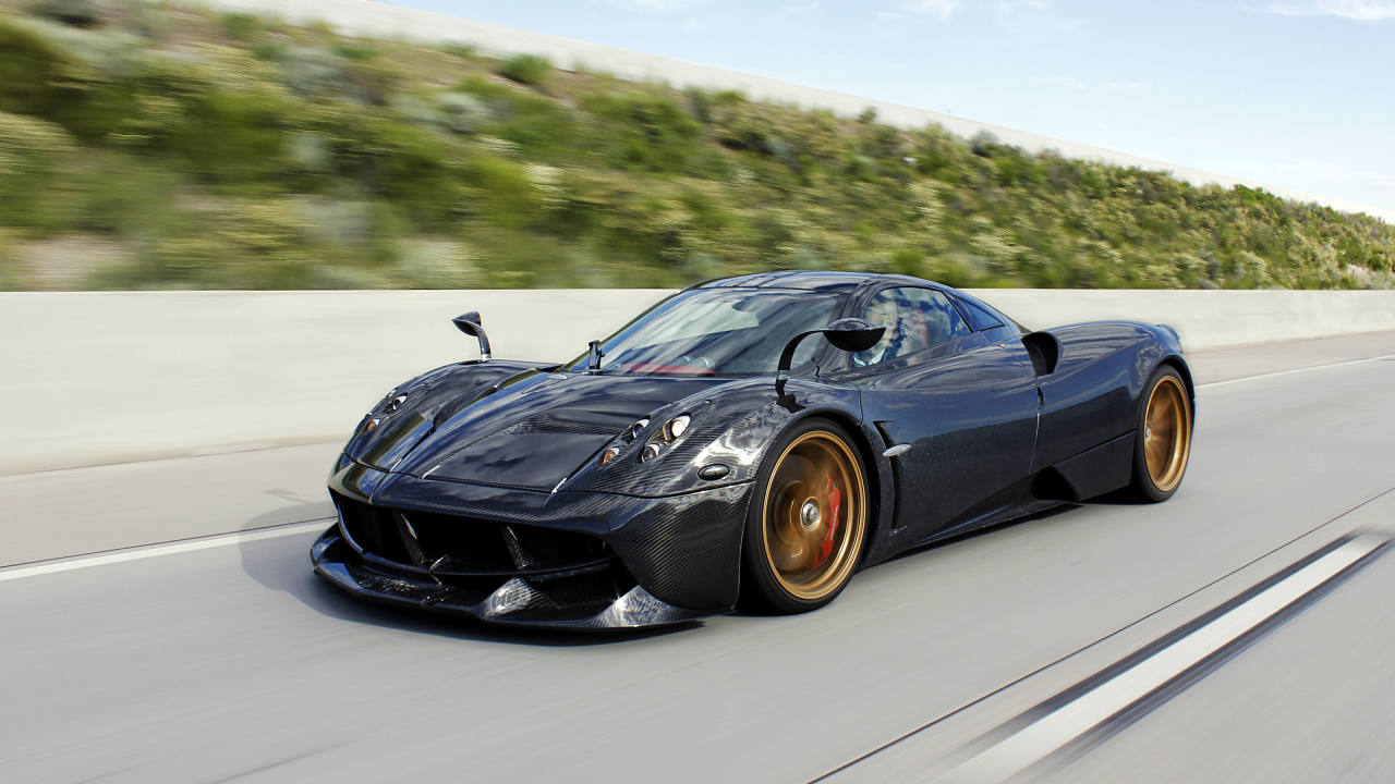 Черный спортивный автомобиль Pagani Huayra на трассе 