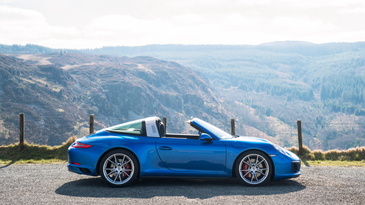 Голубой автомобиль кабриолет Porsche 911 Targa 4S на фоне гор