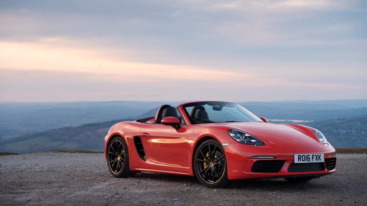 Красный автомобиль кабриолет Porsche 718 Boxster на фоне горизонта 
