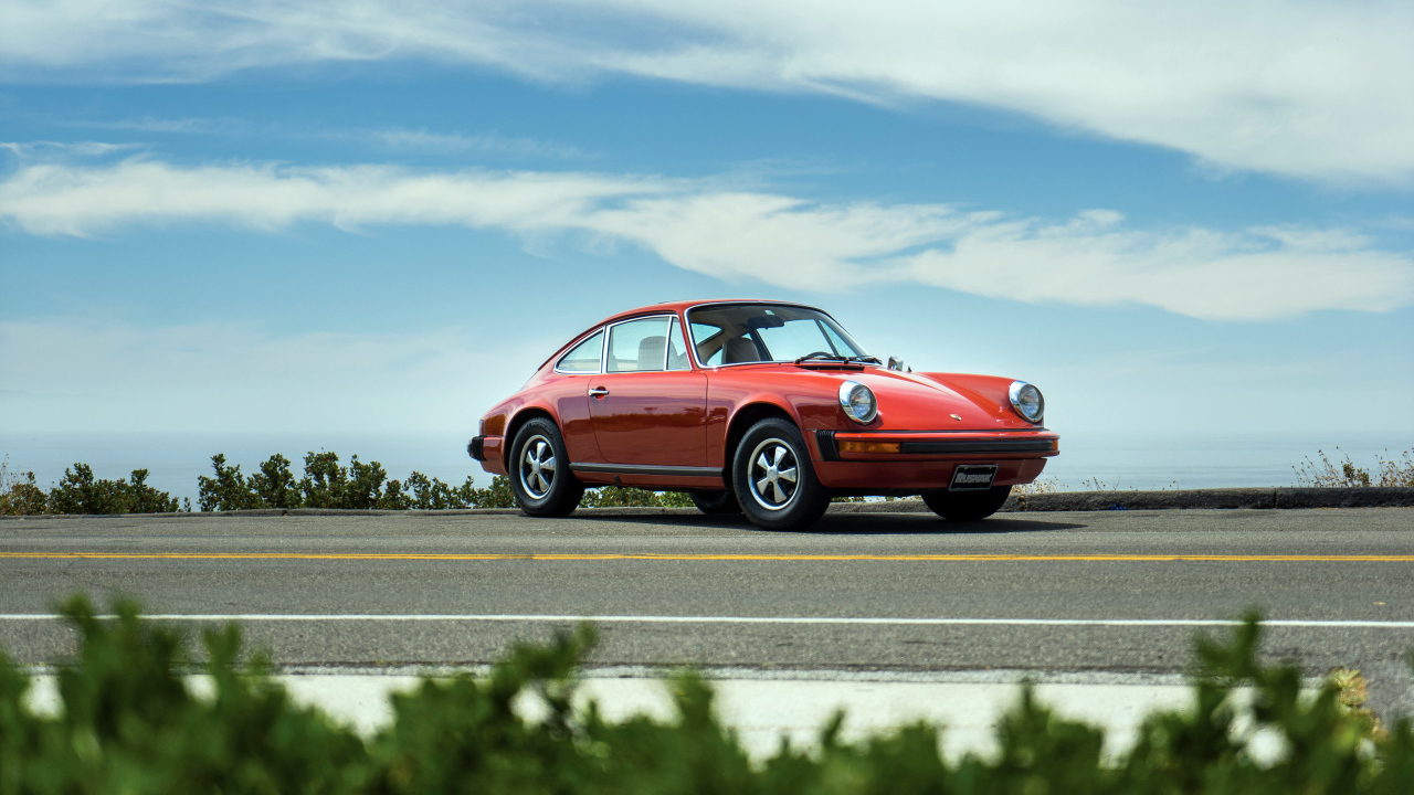 Красный автомобиль Porsche 912 на фоне голубого неба 