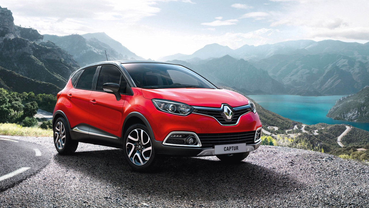 Красный автомобиль внедорожник Renault Captur на фоне гор