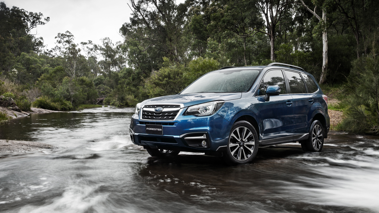 Внедорожник Subaru Forester проезжает через реку 