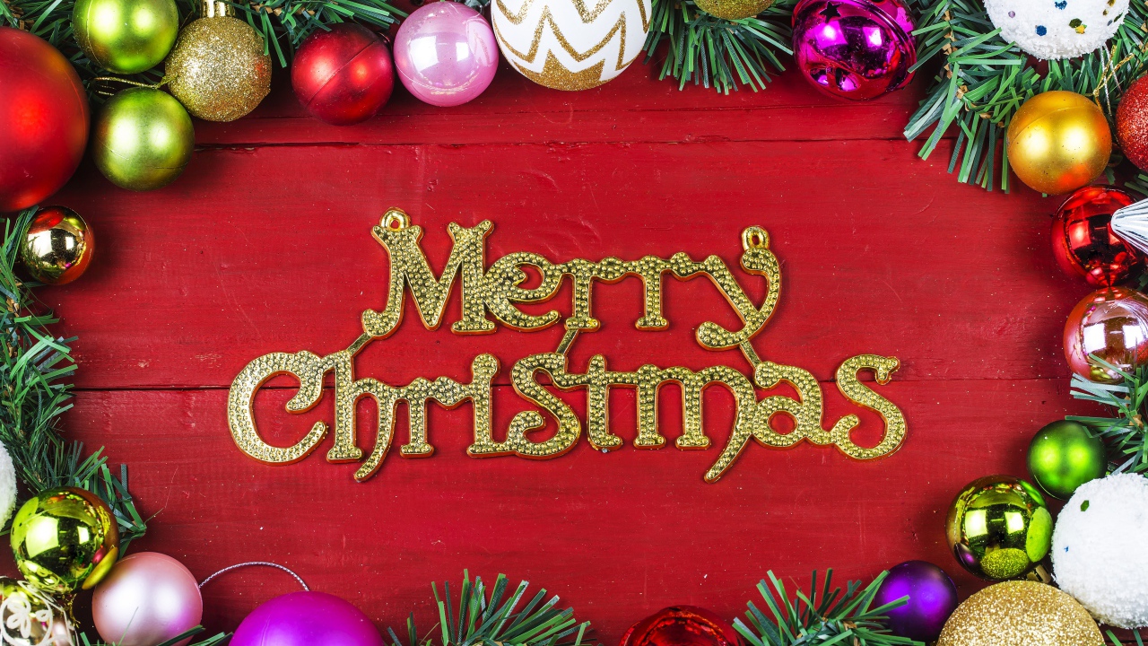 Надпись Merry Christmas на красном фоне с елочными игрушками на Рождество