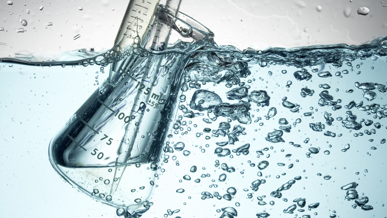 Измерительная чашка в воде с пузырями 