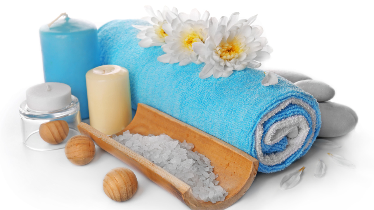 Полотенце, свечи, соль и цветы хризантемы на белом фоне