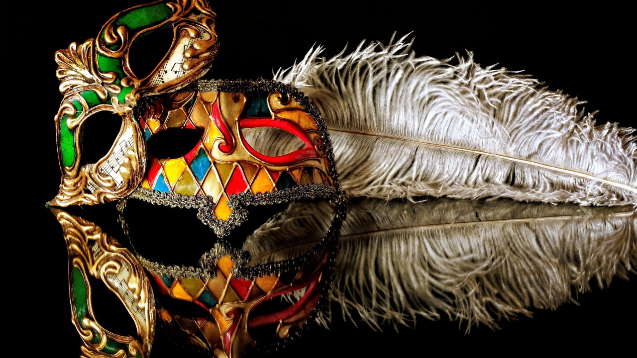 Две красивые маскарадные маски с пером на черном фоне
