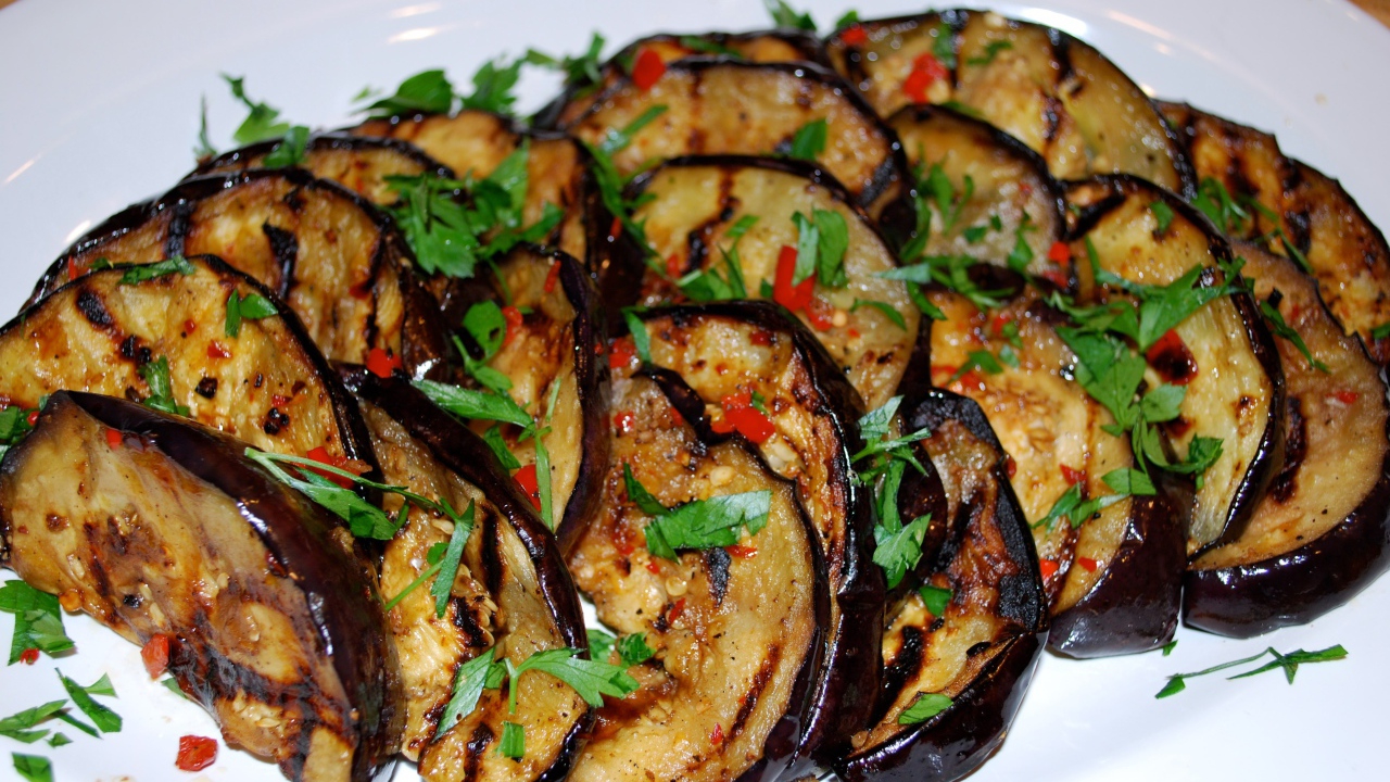 Аппетитные жареные баклажаны на тарелке с зеленью