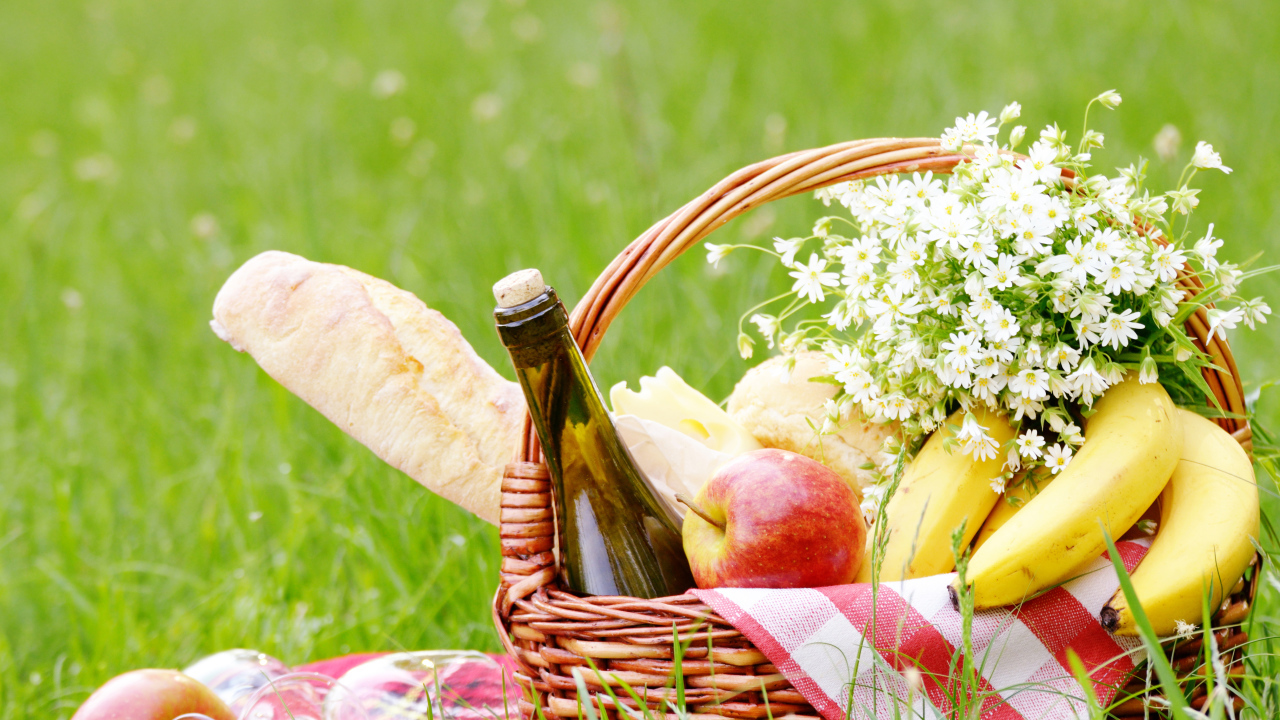 Корзина с продуктами для пикника и букетом белых ромашек