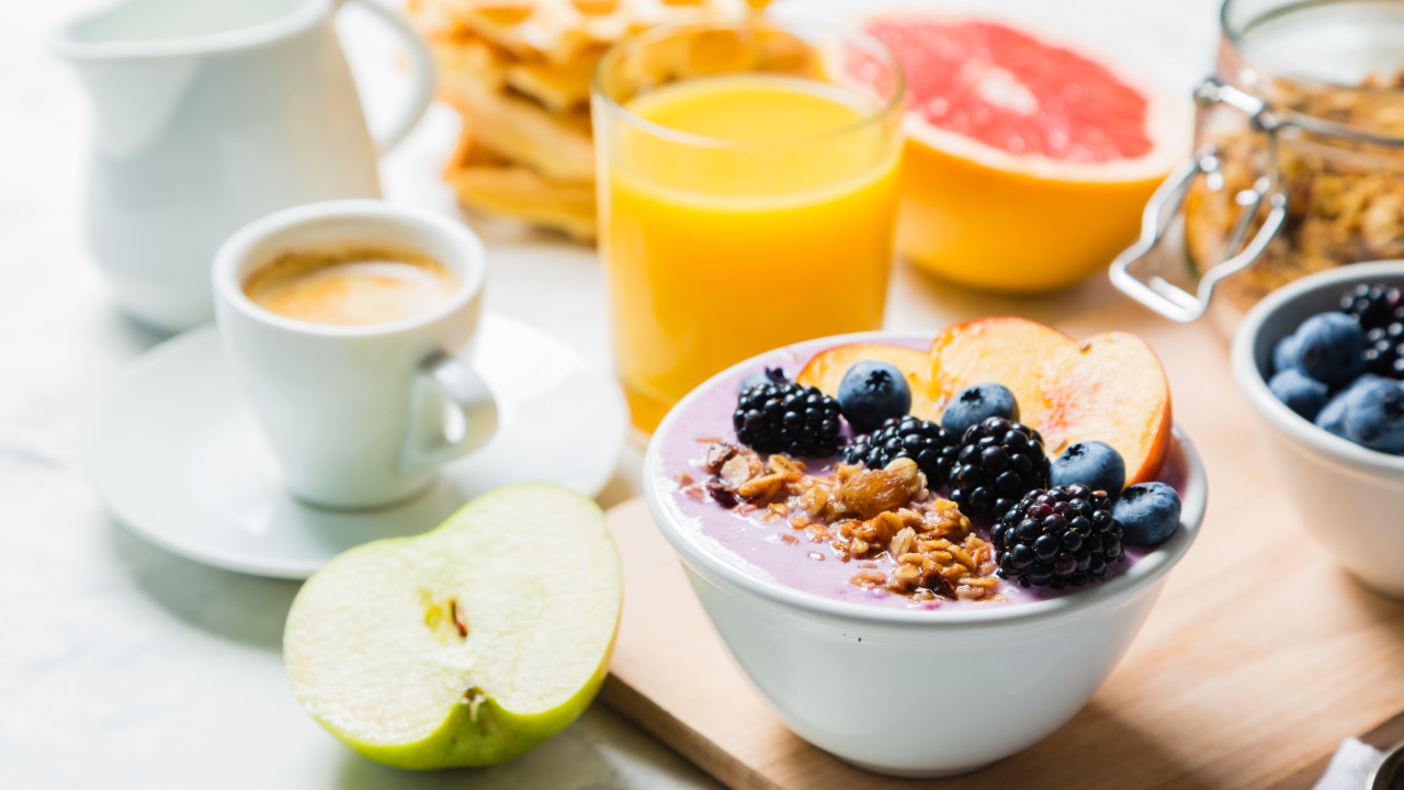 Завтрак с овсянкой, ягодами, фруктами и свежим соком на столе