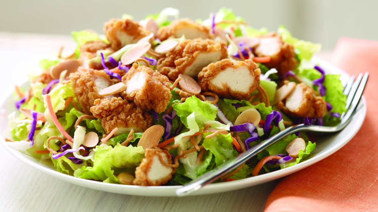 Куриный салат с орехами и капустой на тарелке