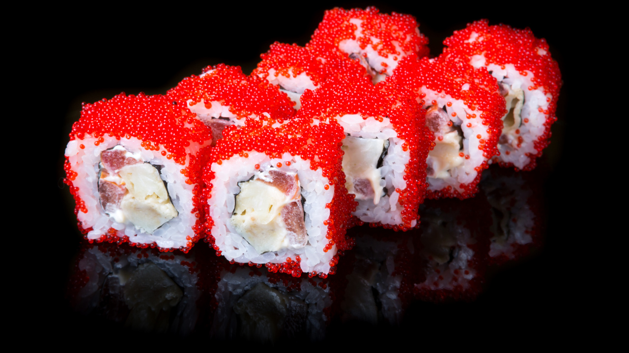 Японские роллы с красной икрой на черном фоне 