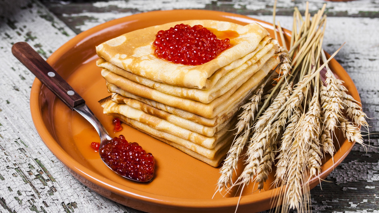 Блины с красной икрой и колосками пшеницы на тарелке