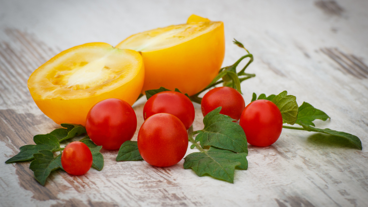 Желтые и красные помидоры на деревянной доске