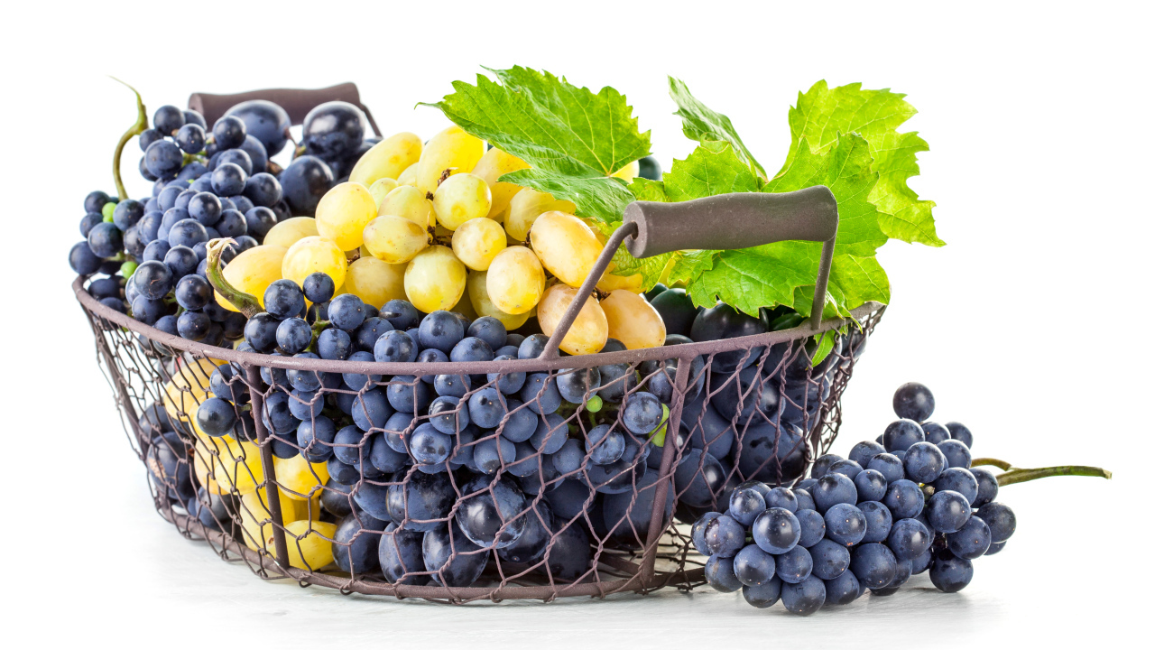 Корзина синего и белого винограда на белом фоне