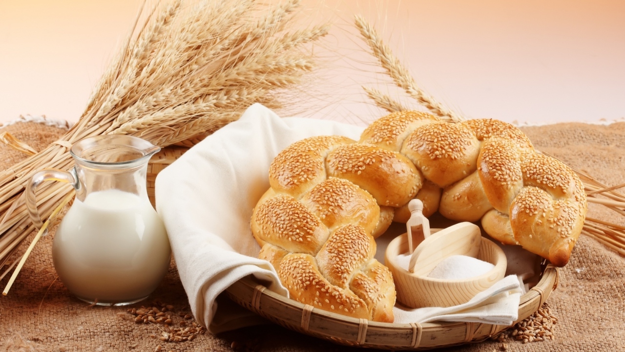 Хлебобулочное изделие и кувшин молока на столе