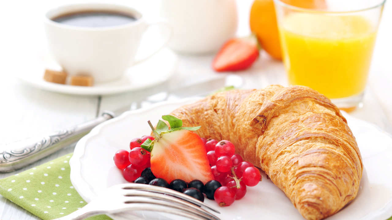 Свежий круассан на белой тарелке с ягодами 
