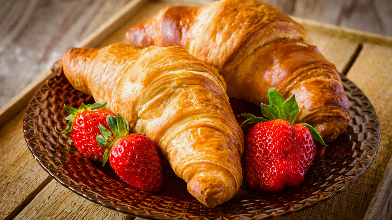 Два свежих круассана со свежей клубникой