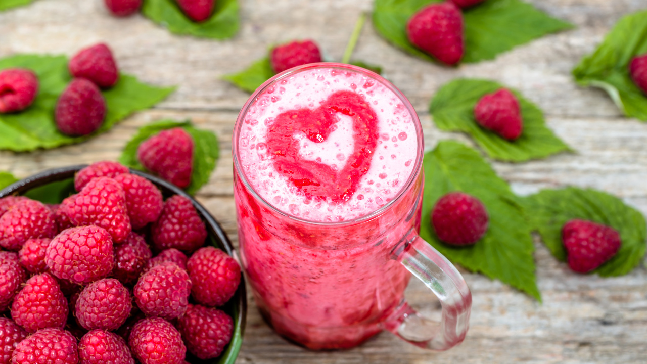 Бокал малинового коктейля со свежими ягодами малины