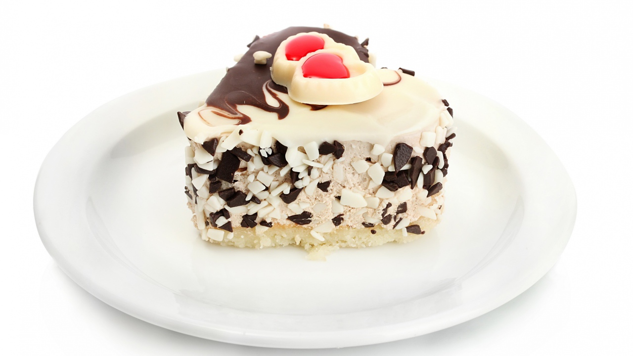 Аппетитное пирожное в форме сердца с шоколадом на белой тарелке