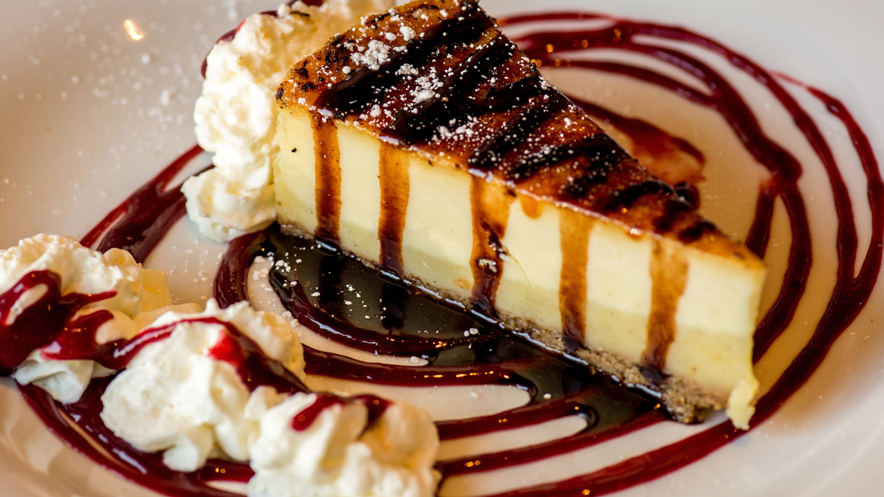 Аппетитный кусок чизкейка со сливками и клубничным джемом