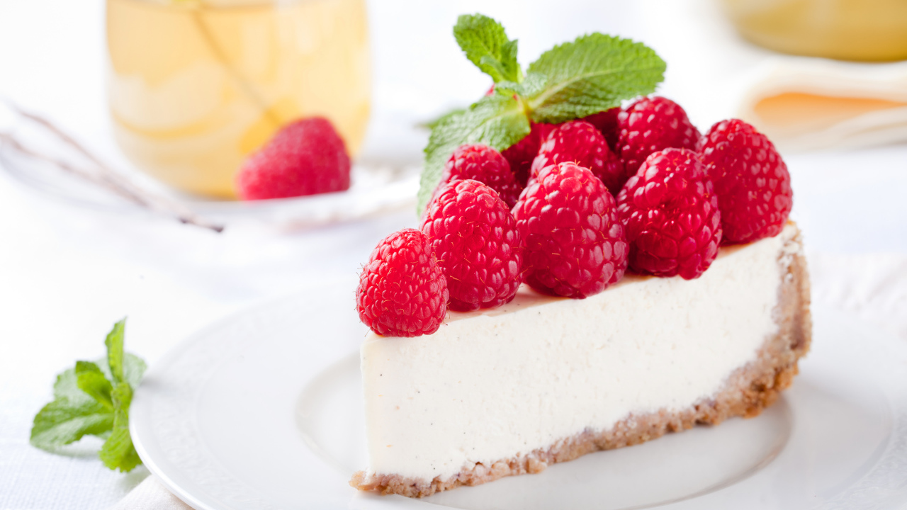 Аппетитный кусок чизкейка со свежими ягодами малины и листьями мяты