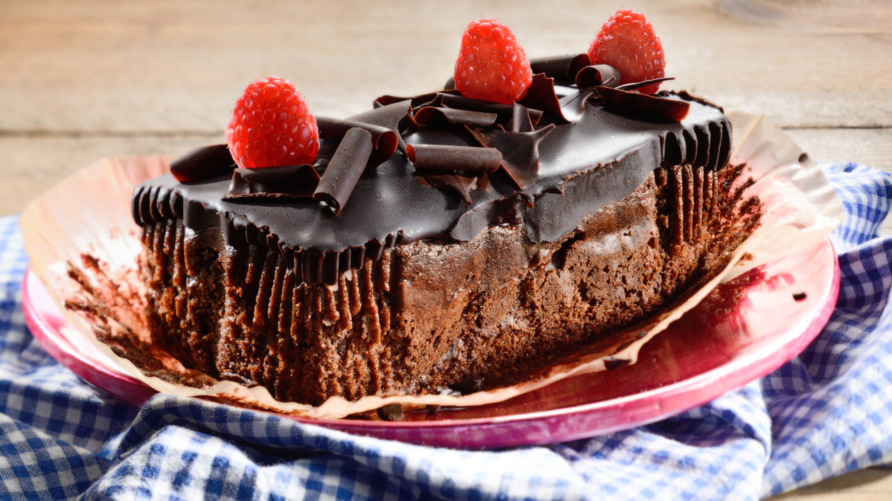 Шоколадное пирожное со свежей малиной на тарелке