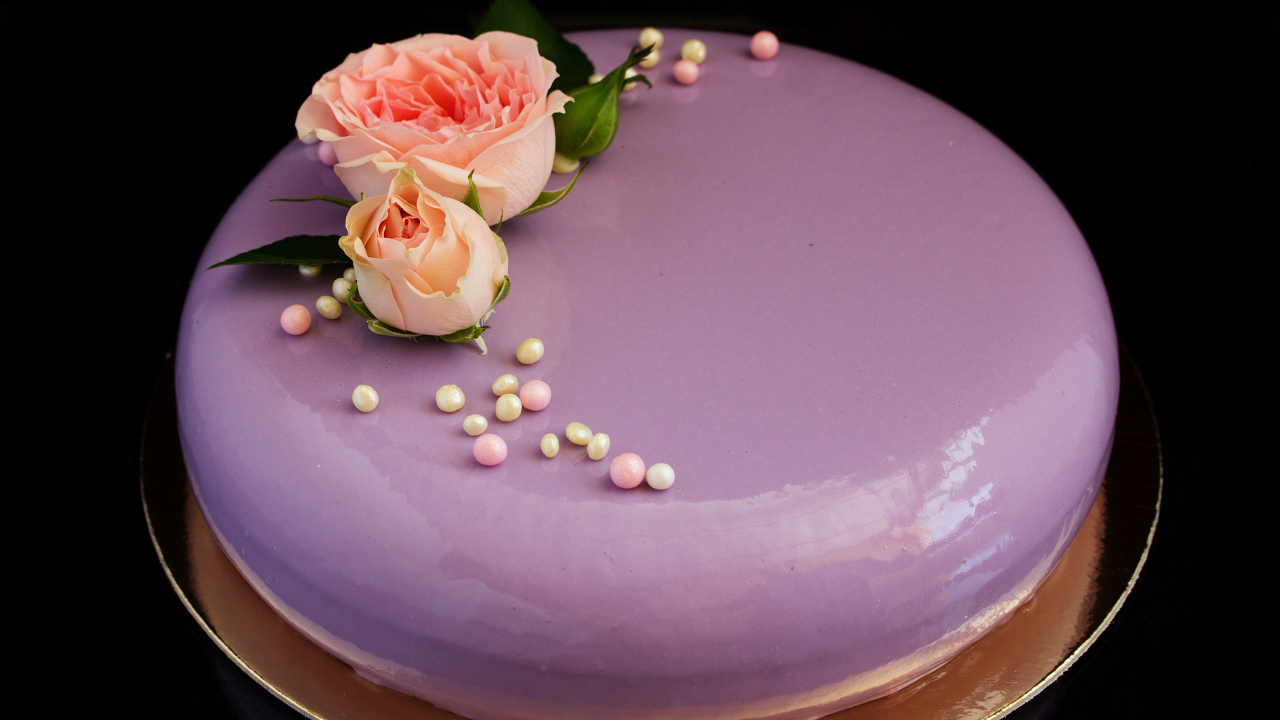 Глянцевый круглый фиолетовый торт с цветами розы на черном фоне