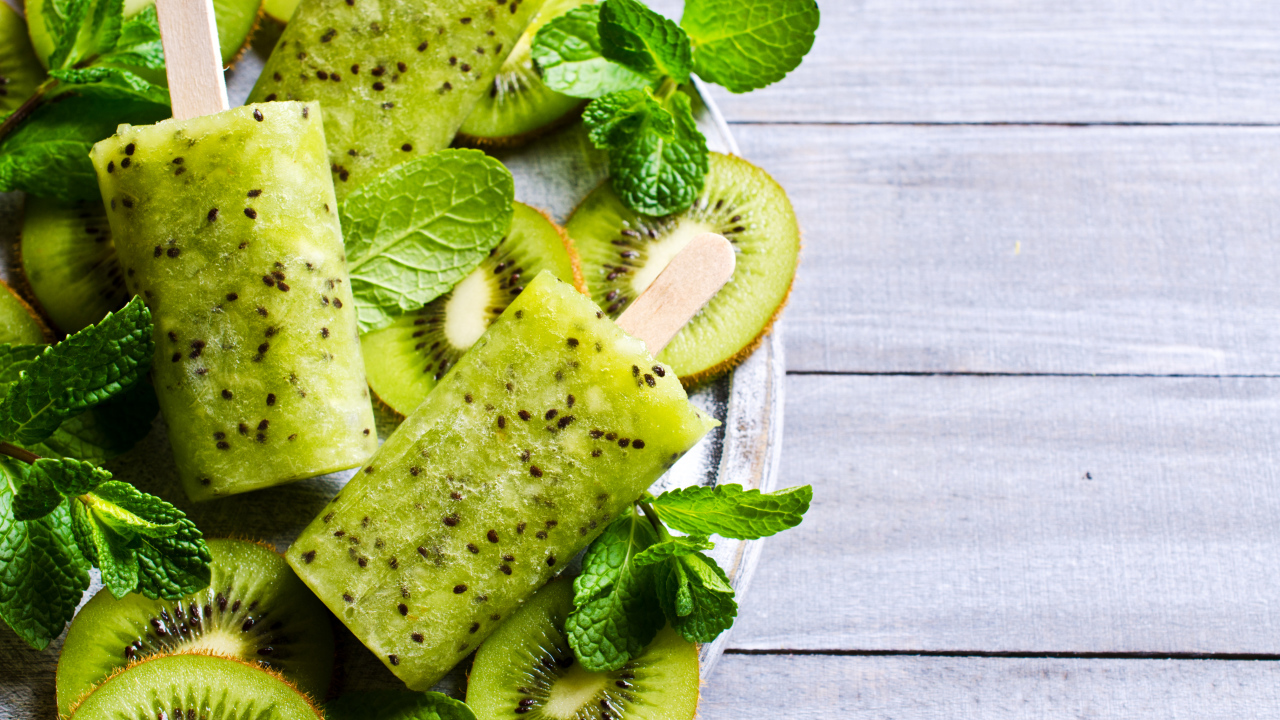 Мороженое с киви и листиками мяты на деревянном столе