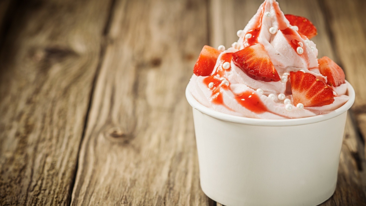 Мороженое с клубникой в белом стакане 