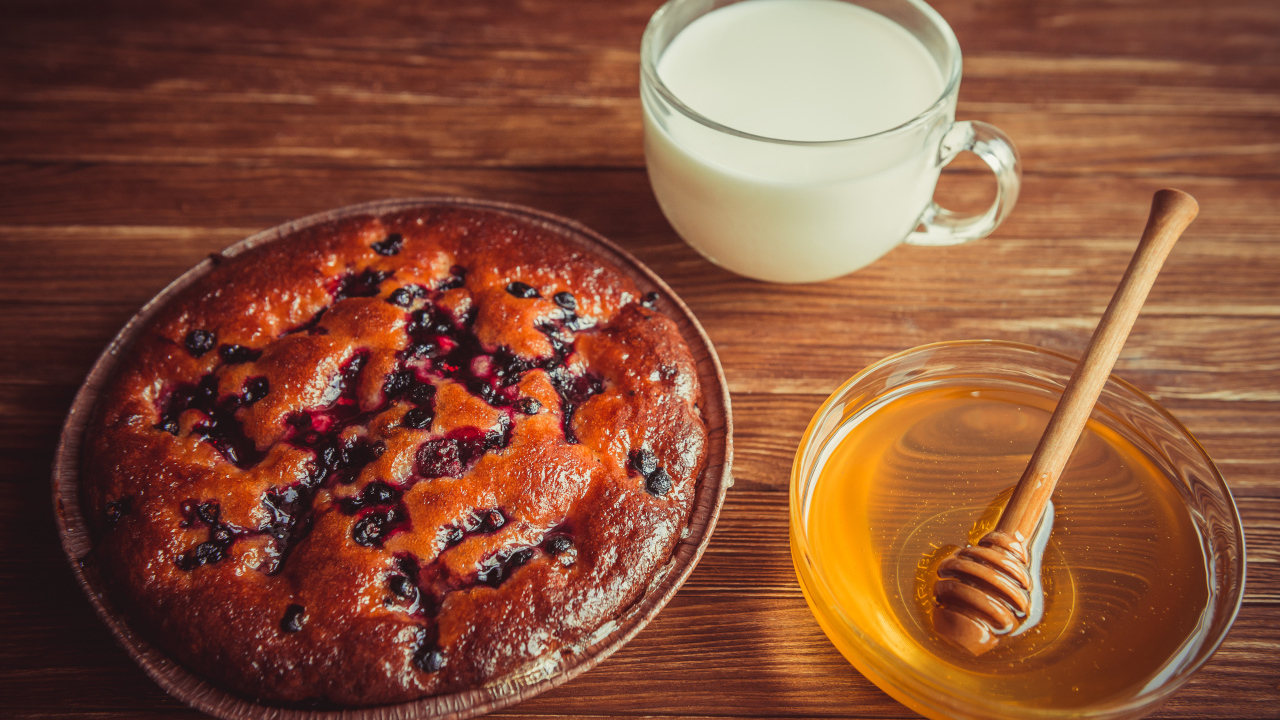 Пирог с ягодами, медом и молоком на столе