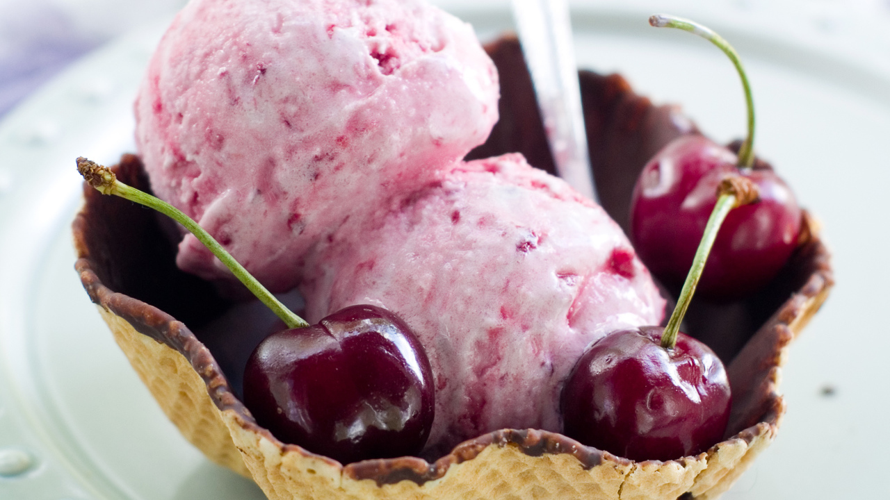 Два шарика вишневого мороженого в вафельной корзинке